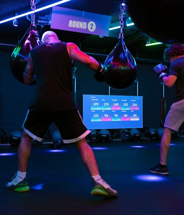 Man performing a core strength exercise in a modern, dark gym.