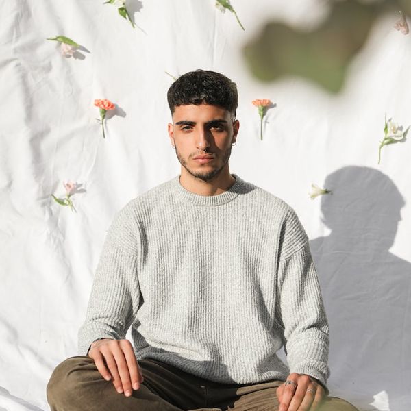 Silhouette of a man in a balancing pose against a calm background.